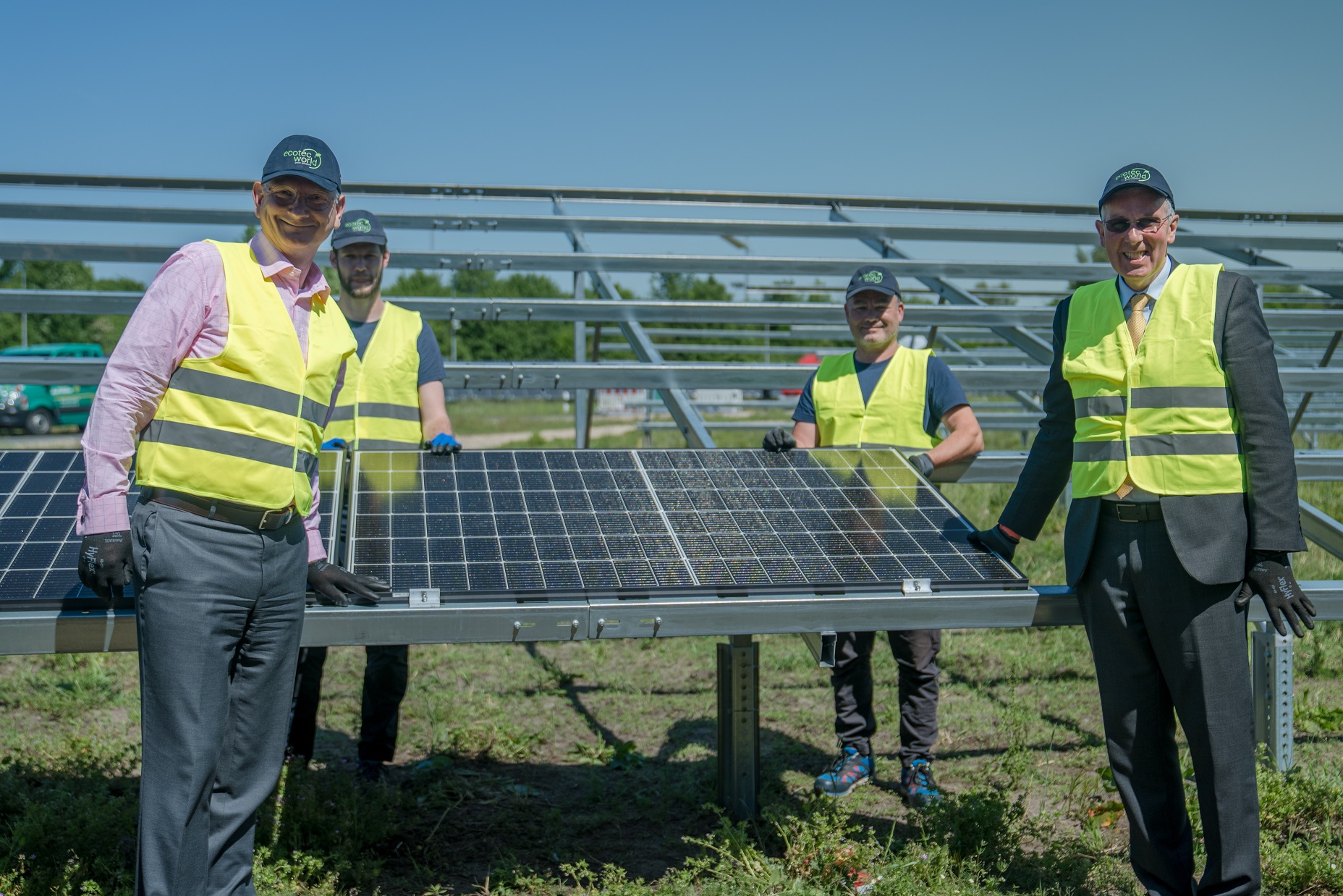 Staff next to solar panel