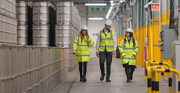 three people in high vis walking on site