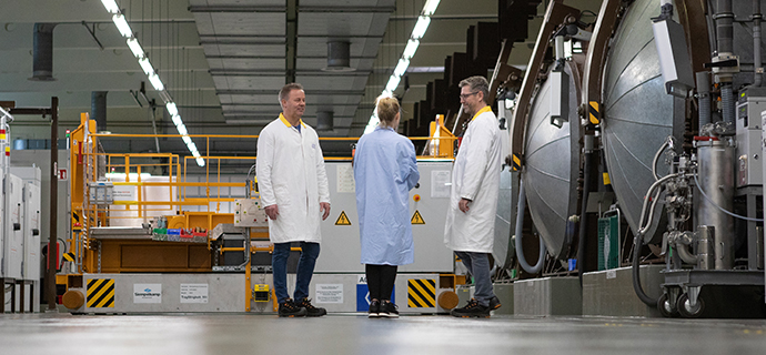 three people next to autoclaves