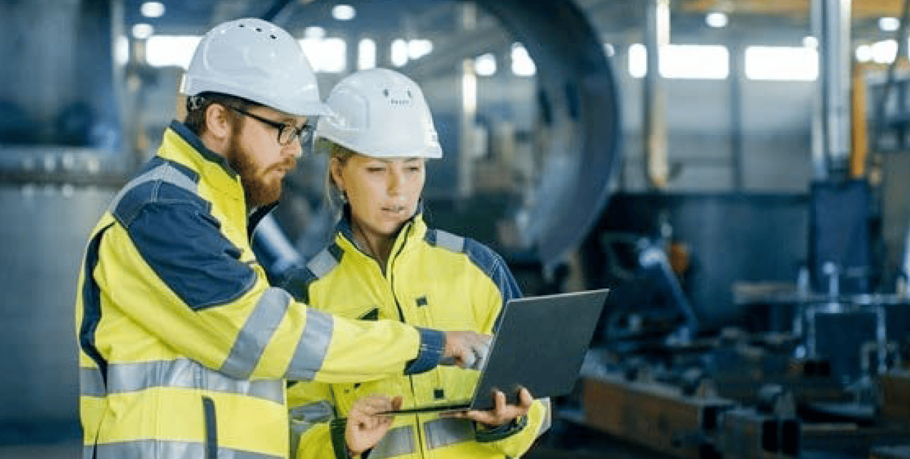 man and woman in high vis looking at a laptop